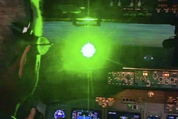 Imagem mostra piloto sendo iluminado por laser verde.